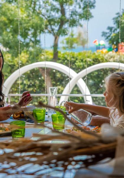 Glückliche Familie beim gemeinsamen Mittagessen in heller Umgebung.