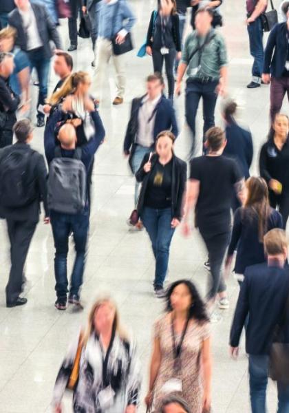 Folla di persone in movimento in un'area pubblica.