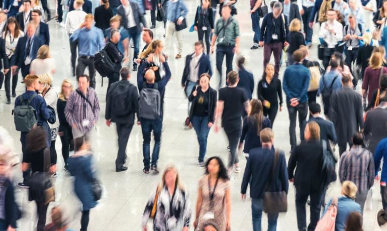 Foule de personnes se déplaçant dans un espace public.